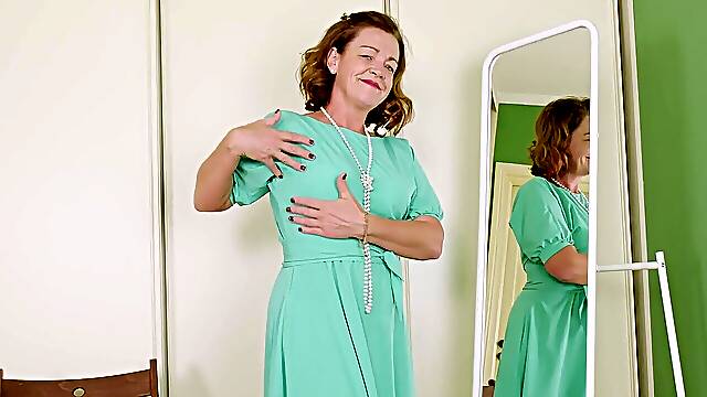 Mature Iris seductively strips down in lacy lingerie